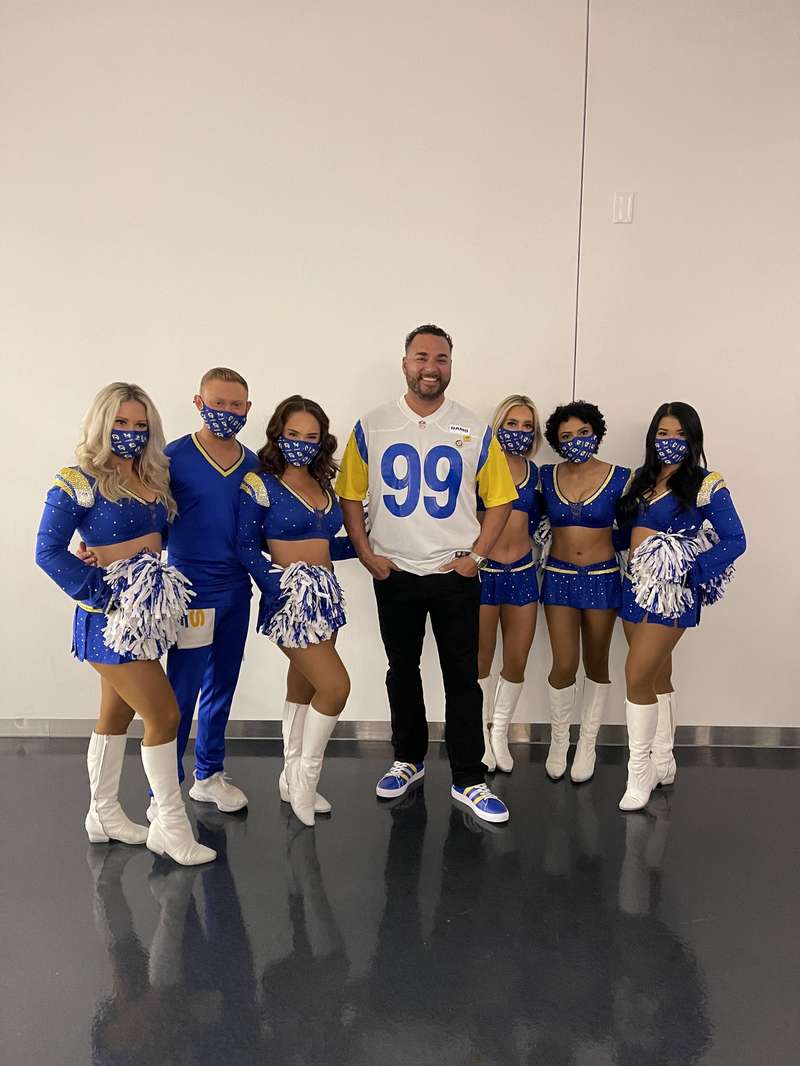 Fan with Rams cheerleaders in masks
